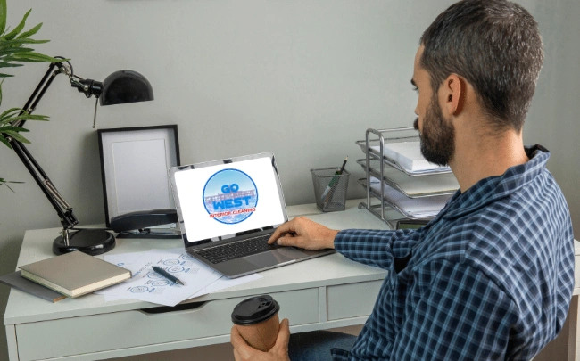 man looking at Go West Interior Cleaning logo on laptop